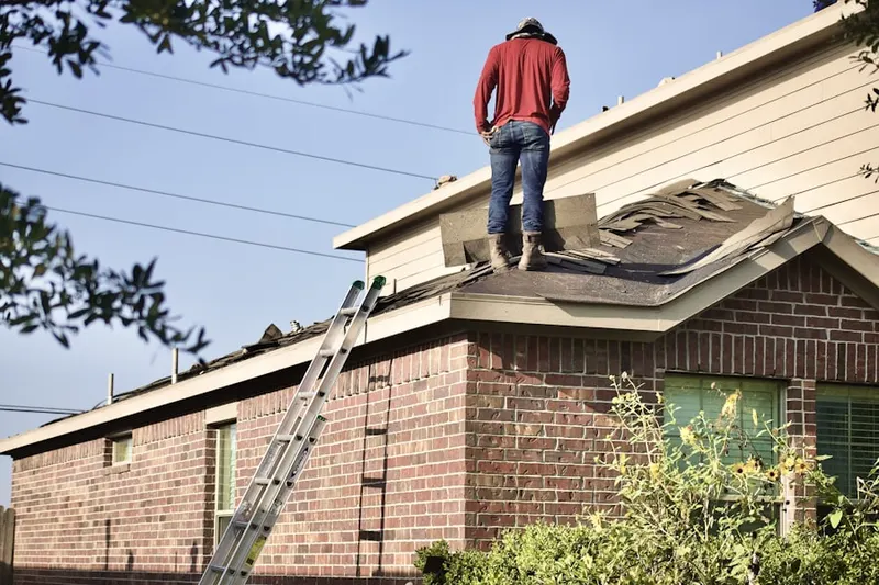 Professional roofer working on a residential roof in Thorp